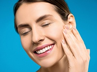 Woman with attractive smile placing hand on face