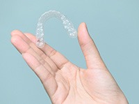 Closeup of patient holding clear aligner