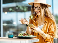 Woman smiling while eating lunch outside