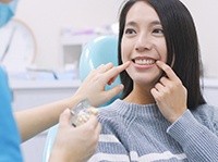 A woman pointing to her tooth
