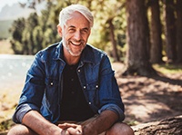 man with dental implants in Belchertown sitting by a lake