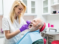 dental hygienist cleaning a patient’s mouth