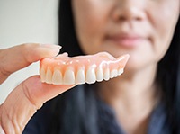 Woman holding dentures