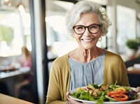 Smiling older woman holding plate of nutritious food