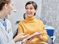 Mature woman speaking with dental team member