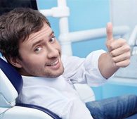 Man in dental chair giving thumbs up