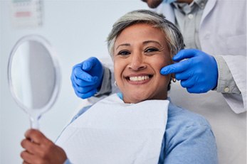 woman pulling back cheek to reveal a missing tooth