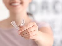 A woman holding a mouth guard