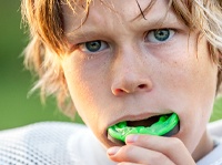 A young boy wearing a sports guard