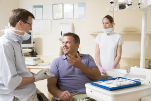 Man talking to dentist in dental exam room