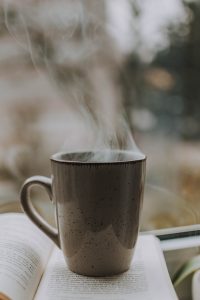 Hot cup of coffee on a book.