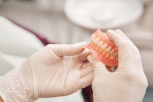 Dentist holding pair of dentures